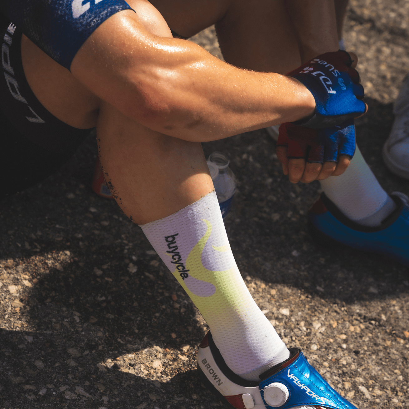Grace Brown sitting on the ground wearing cycling clothes - sweaty arms and legs.